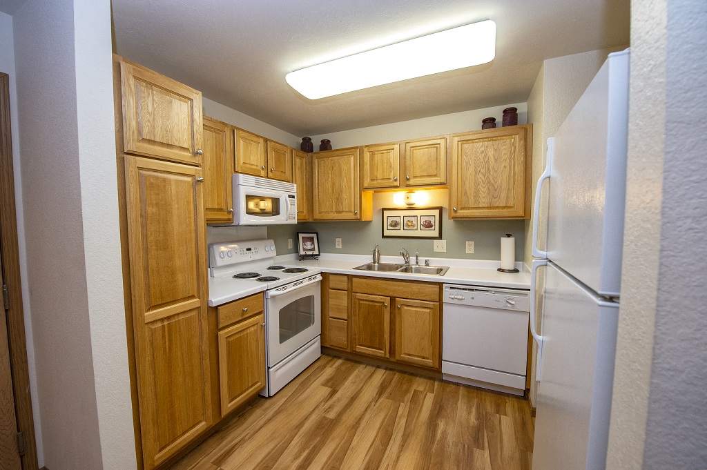 a kitchen with white appliances and wooden cabinets