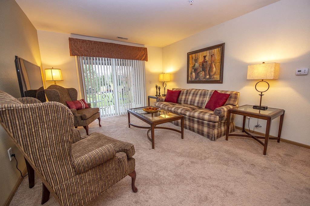 a living room with couches and chairs and a sliding glass door