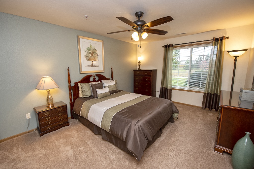 a bedroom with a bed and a ceiling fan