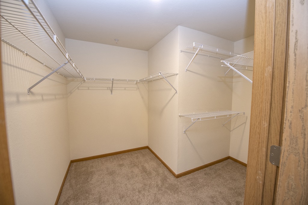 the spacious walk in closet in the master bedroom of a manufactured home