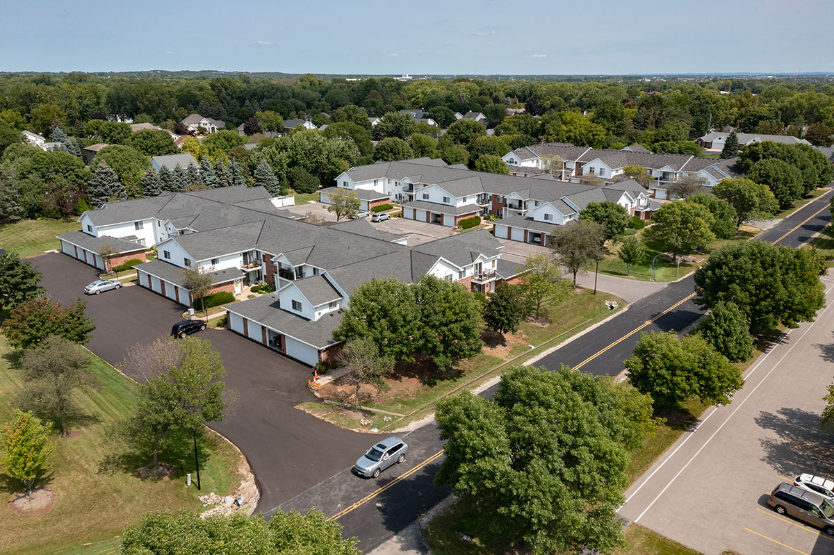 an aerial view of a neighborhood of houses with cars parked