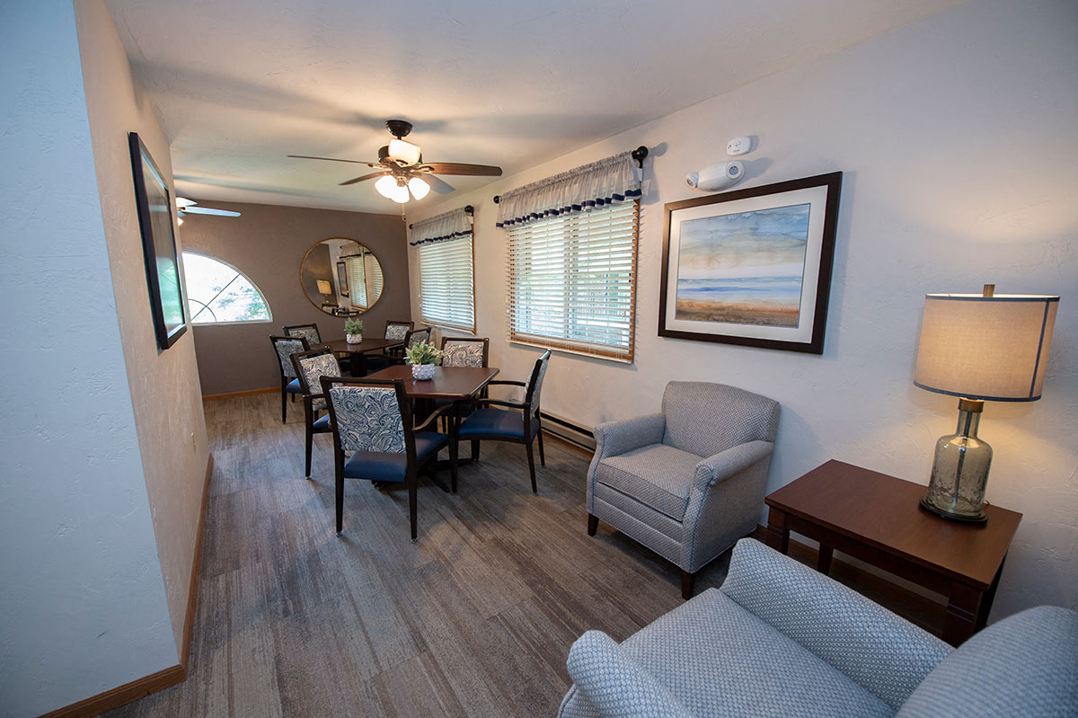 a living room and dining room with a table and chairs