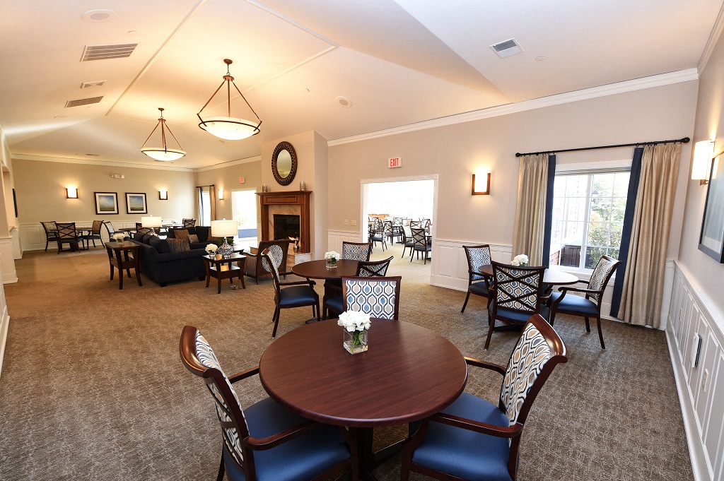a large living room with tables and chairs and a fireplace