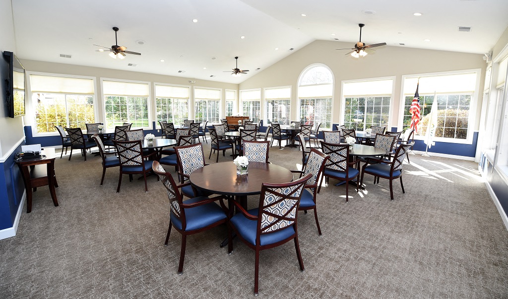 a large dining room with tables and chairs and windows