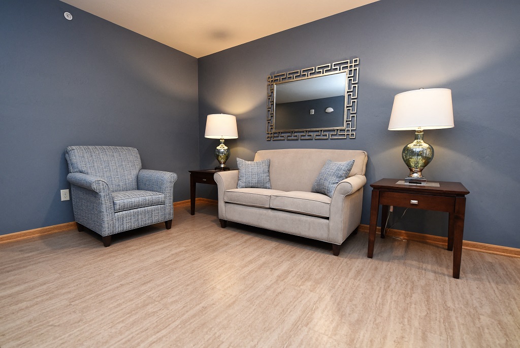a living room with two chairs and a mirror