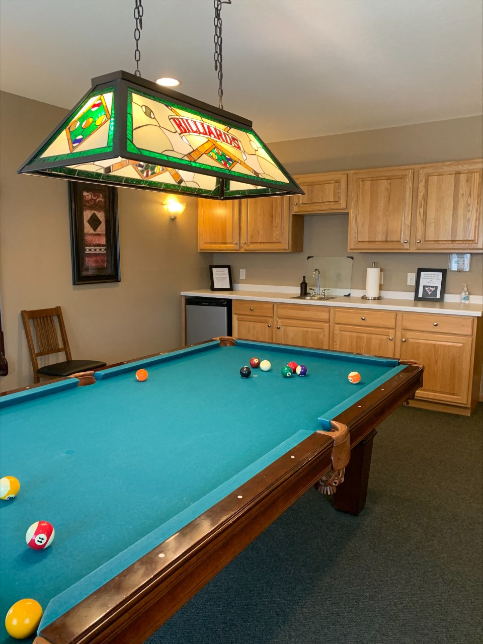 a pool table in a room with a light over it