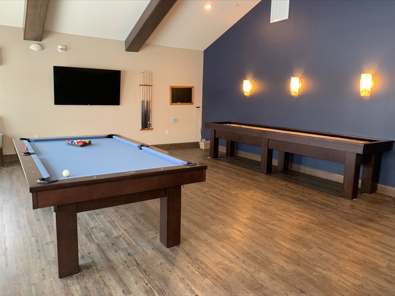 a game room with two pool tables and a tv