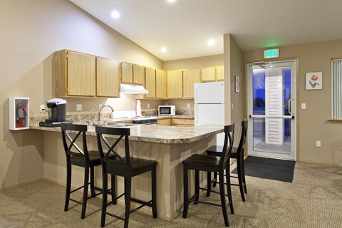 a kitchen with a large counter top with bar stools
