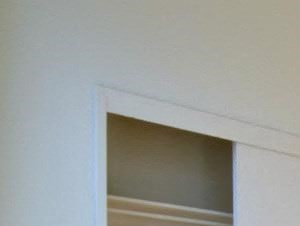 an empty living room with wooden floors and white walls