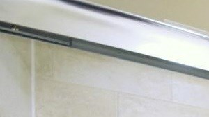 a white bathroom with a shower and a sink