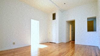 an empty room with a wood floor and white walls