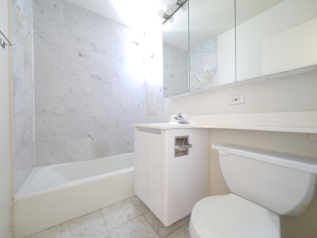 a bathroom with a toilet and a tub and a sink