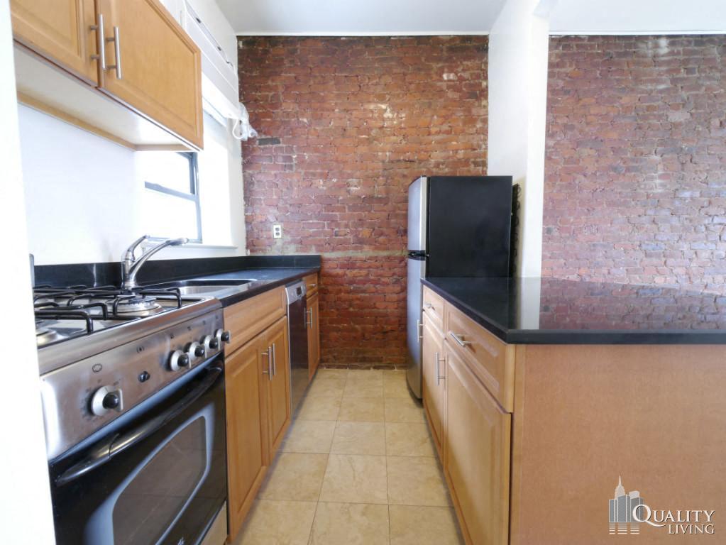 a kitchen with an exposed brick wall and black counter tops