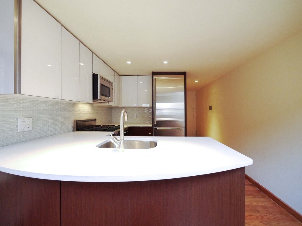a kitchen with a white counter top and a sink