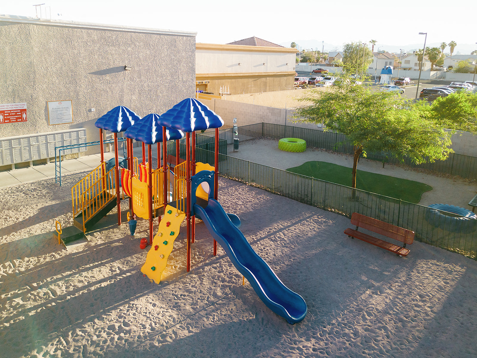 a playground with a swing set and slides in a park