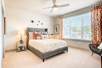 a bedroom with a bed and a ceiling fan