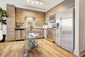 a kitchen with stainless steel appliances and wooden floors