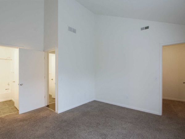 an empty living room with white walls and a door