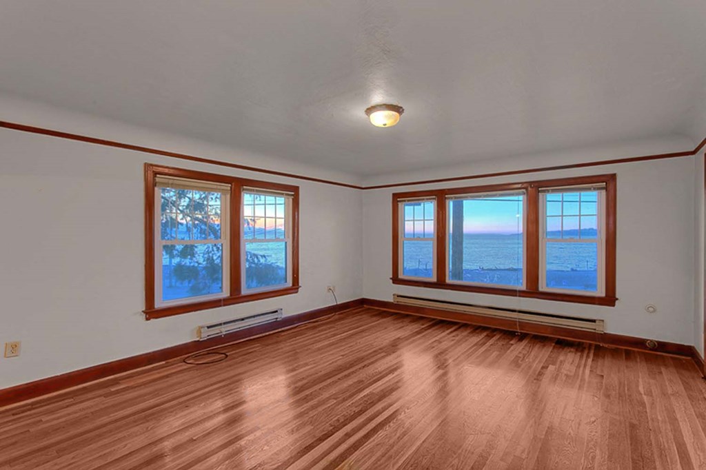 an empty living room with wood floors and windows