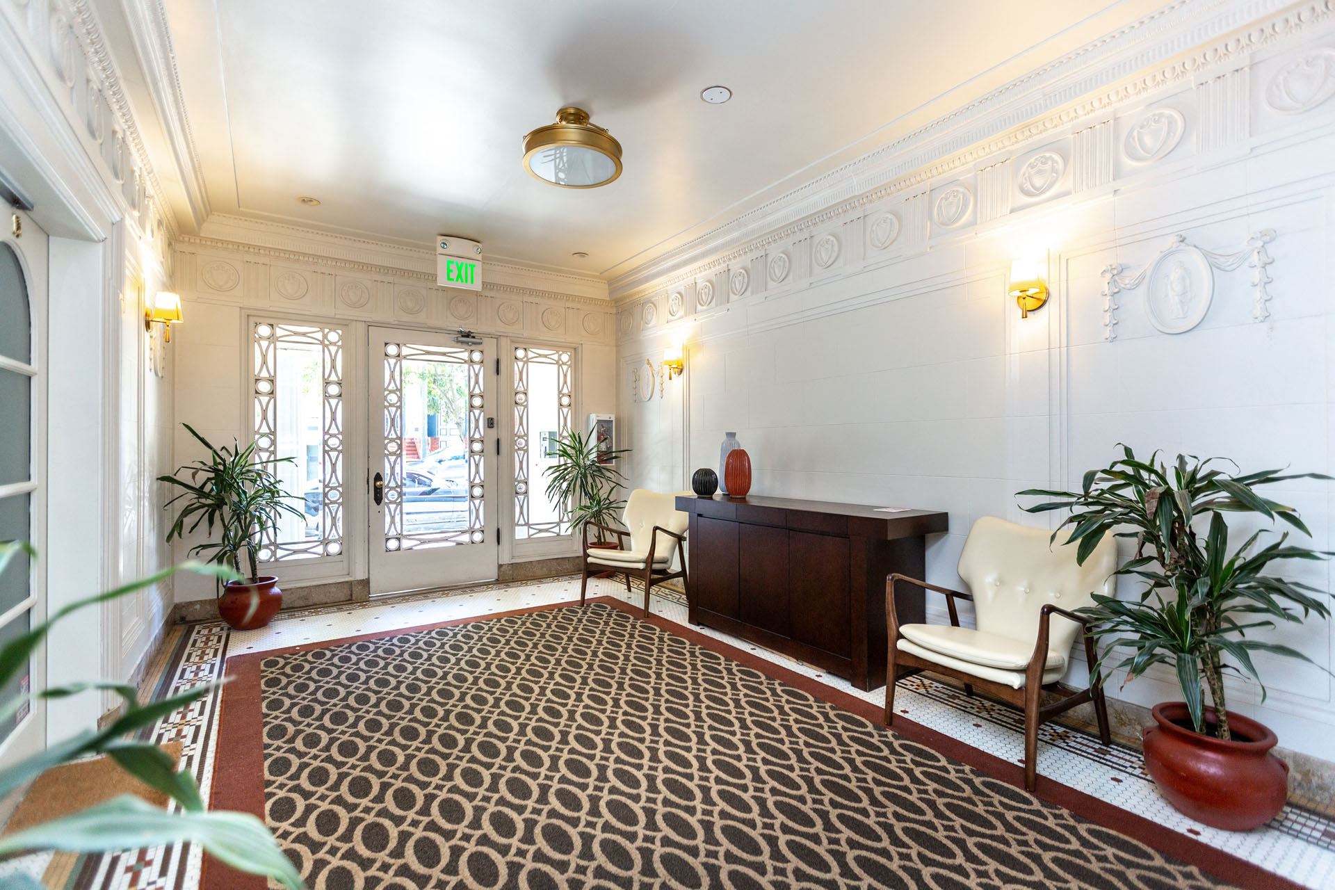 A room with a patterned carpet and a wooden cabinet.