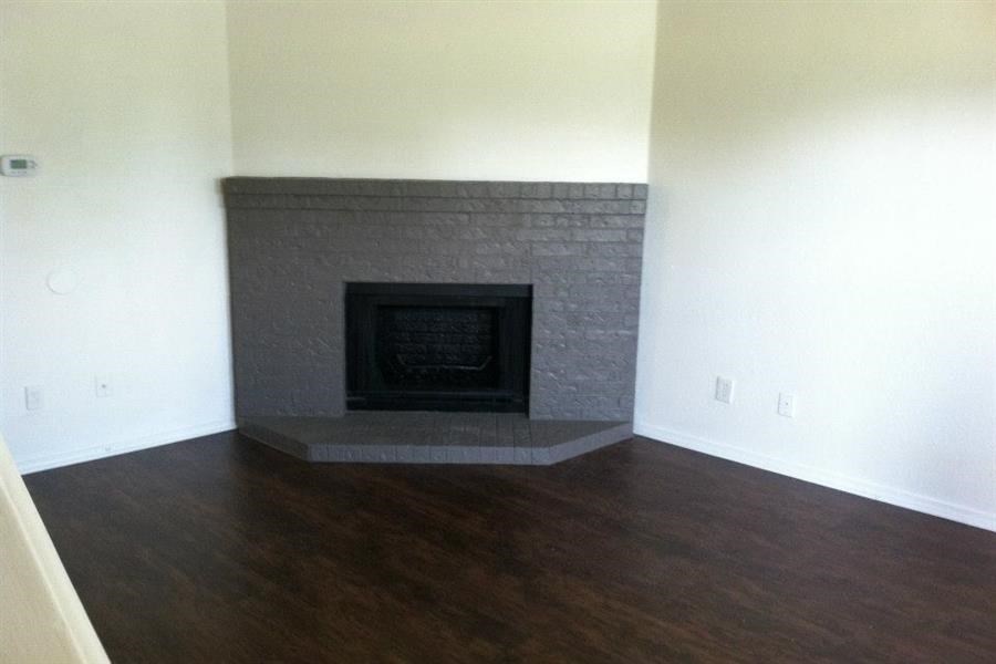 a living room with a stone fireplace and a wooden floor