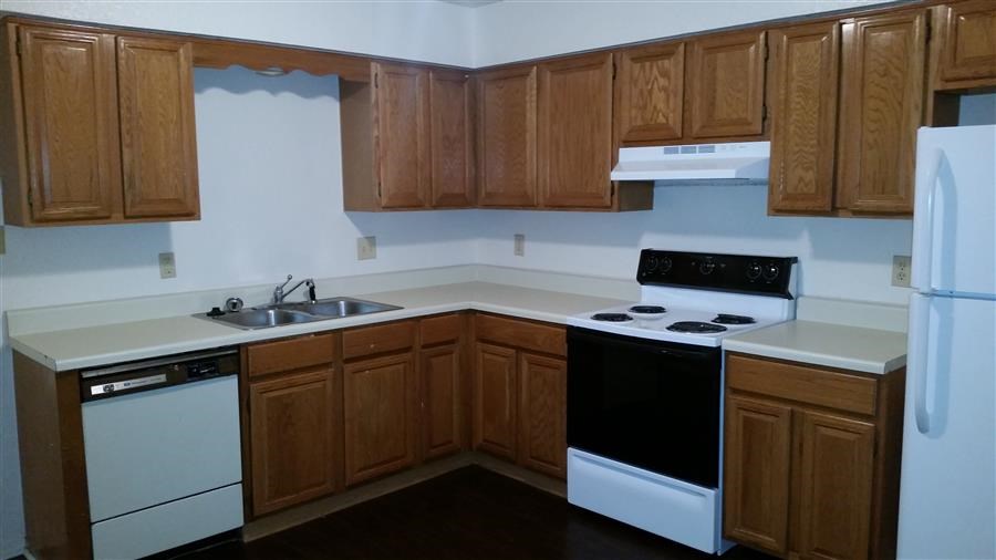 a kitchen with white appliances and wooden cabinets