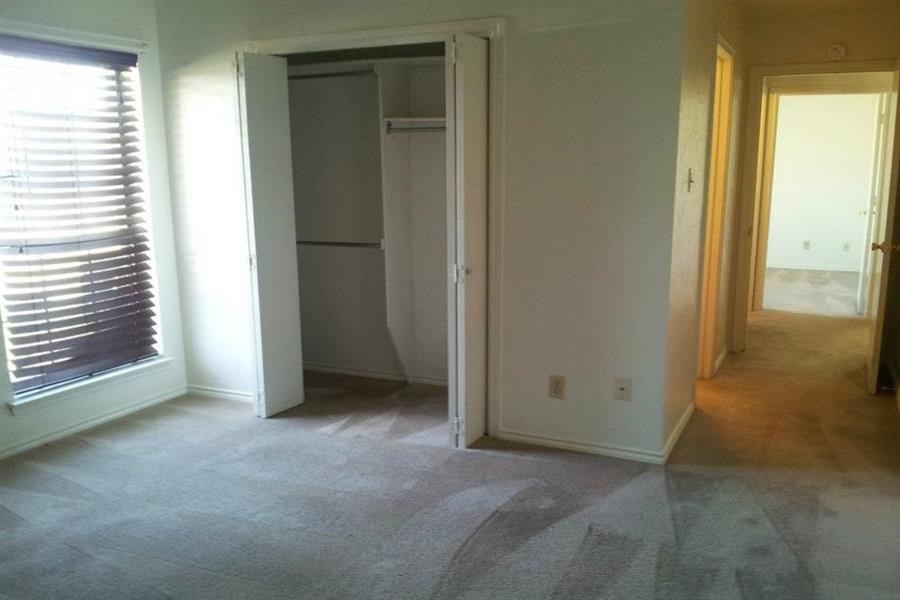 an empty living room with a closet and a window