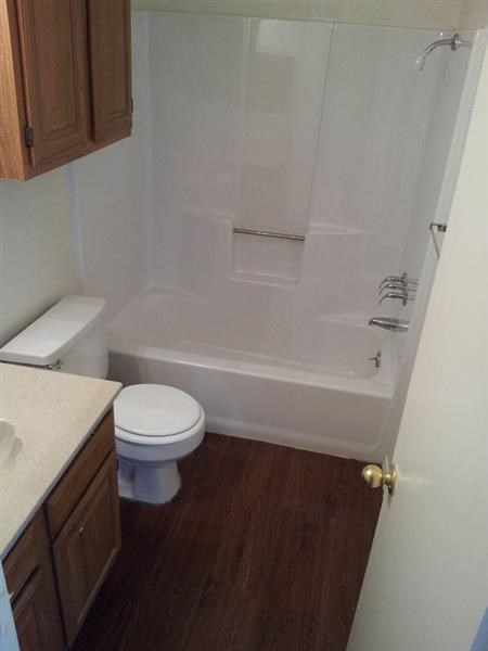a white bathroom with a toilet and a shower