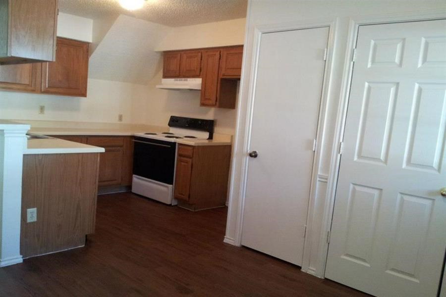 a kitchen with a stove and a white door