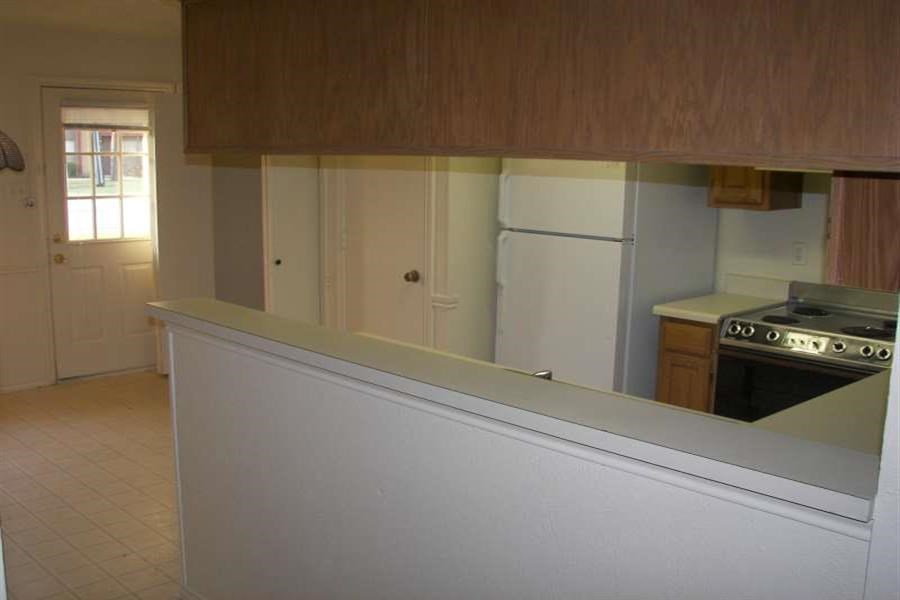 an empty kitchen with a stove and a refrigerator