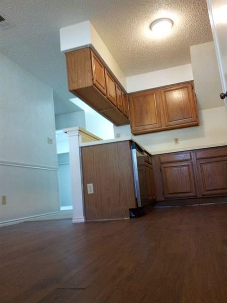 an empty kitchen with wooden floors and wooden cabinets