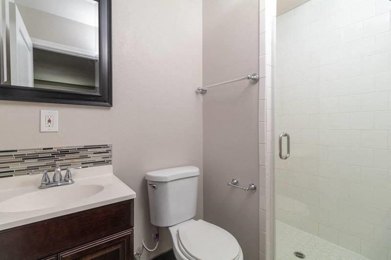 a bathroom with a toilet and a sink and a shower