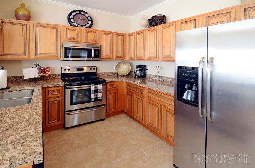 a kitchen with stainless steel appliances and wooden cabinets