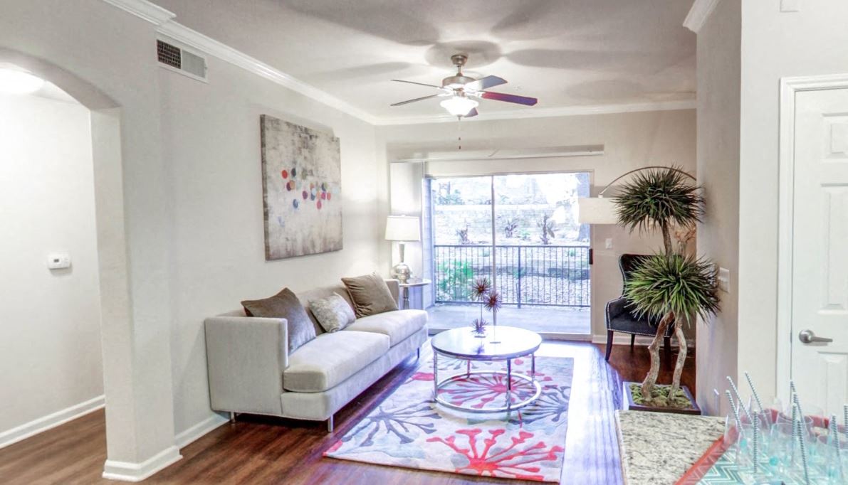 a living room with a couch and a ceiling fan