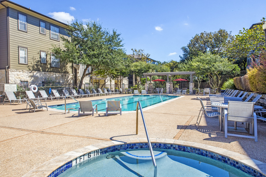 Resort Style Pool with water feature and poolside umbrella seating