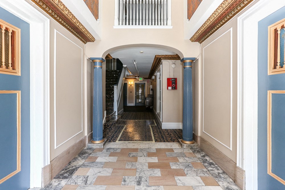 the hallway of a building with columns and an archway