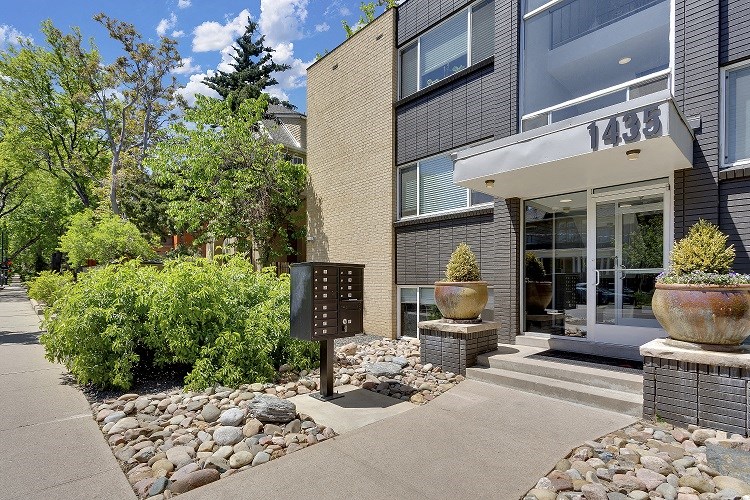 a sidewalk in front of a building with a mailbox