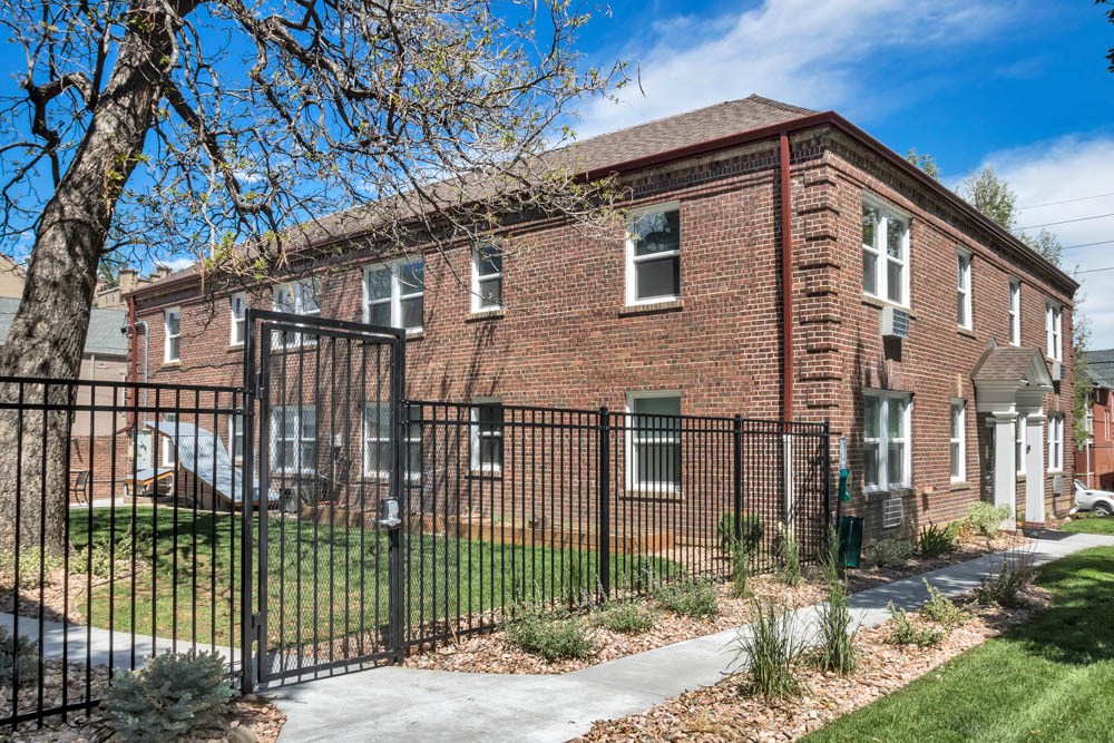 a large brick house with a wrought iron fence in front of it