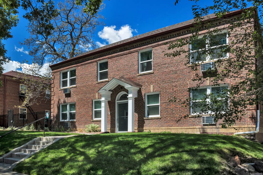 a red brick building with grass in front of it