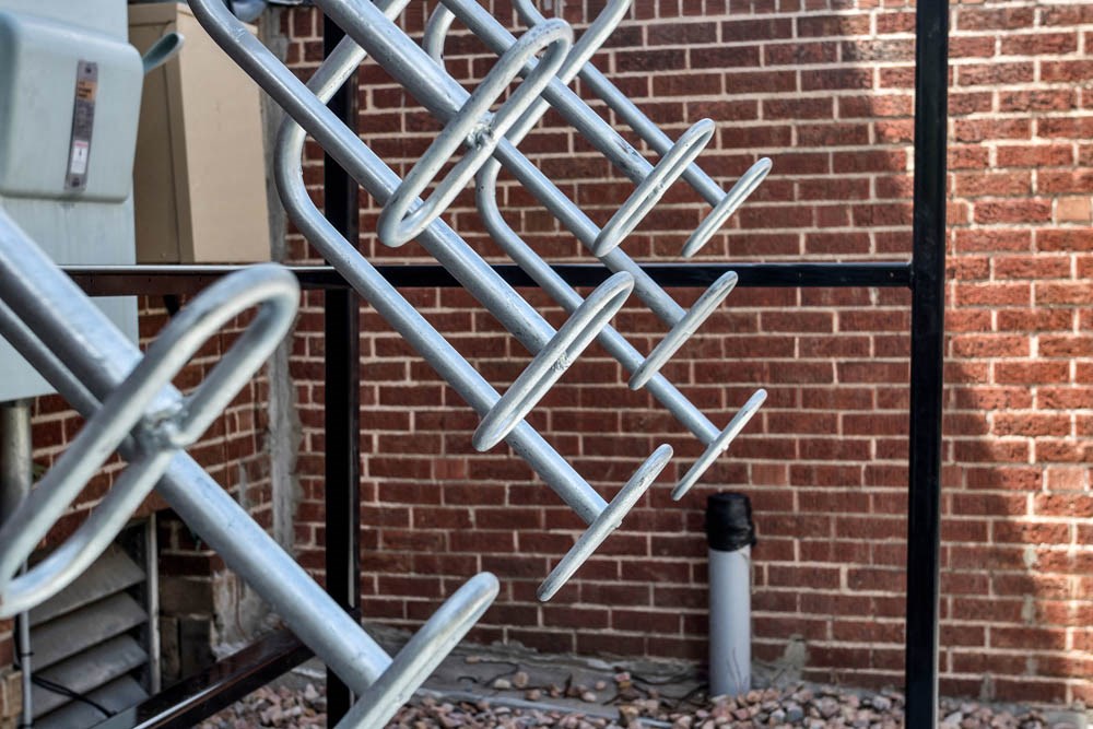 a group of metal scaffolding against a brick wall