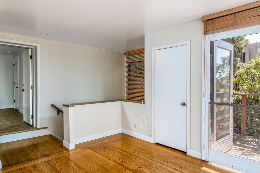 a living room with a large window and a door to a balcony