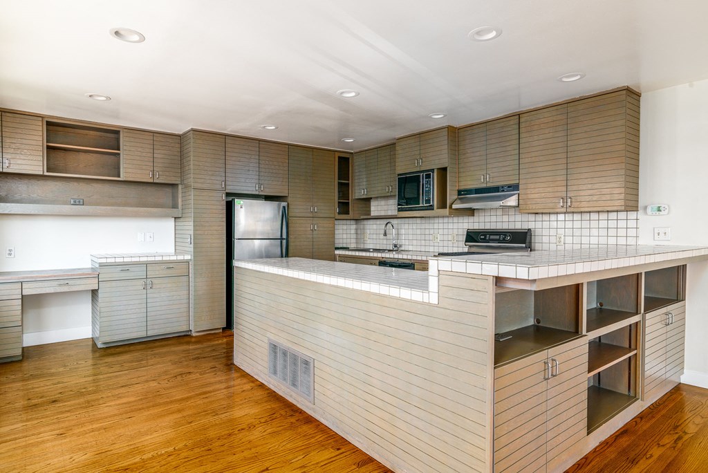 a kitchen with a large island and a refrigerator