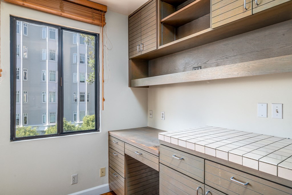 a kitchen with a window and a counter top and cabinets