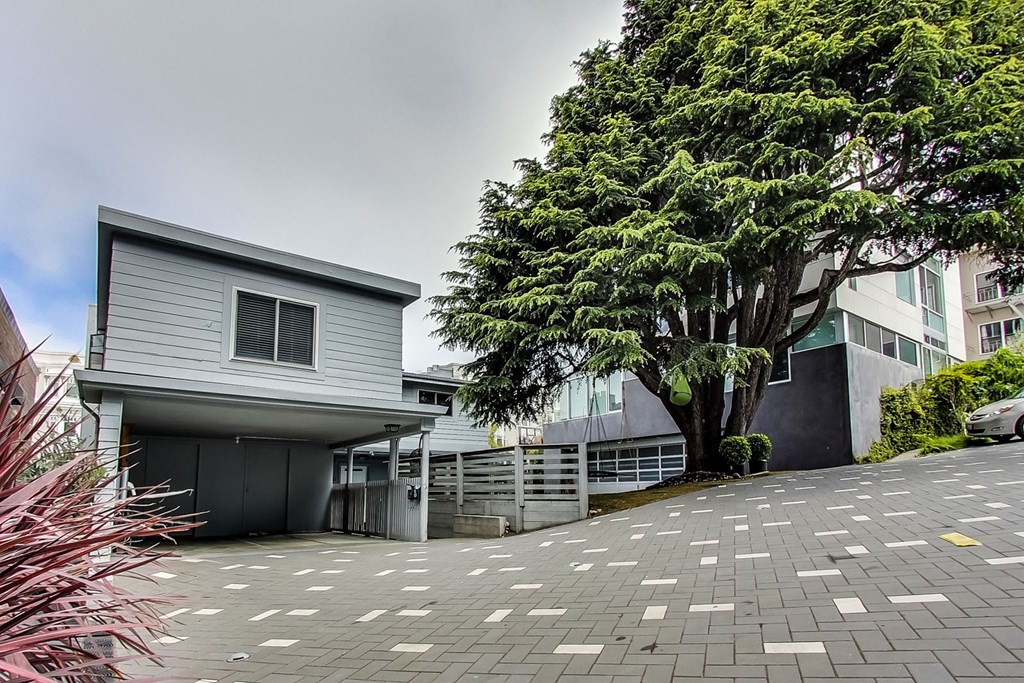 a house with a driveway and a tree