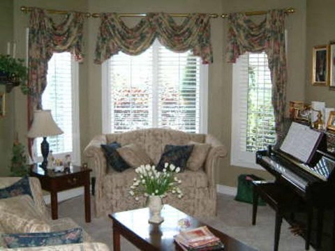 A living room with a couch, a coffee table, and a piano.
