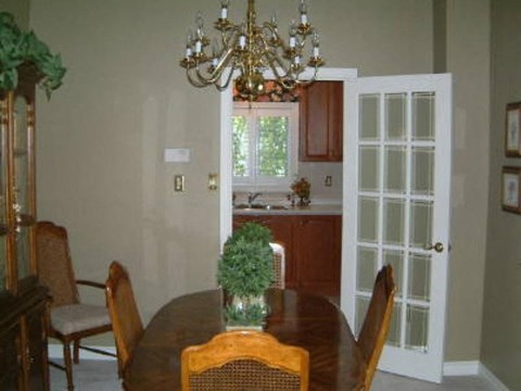 A dining room with a wooden table and chairs.