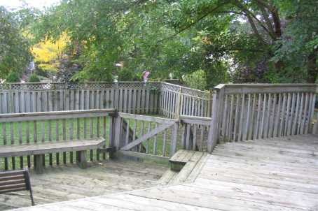 A wooden deck with a bench and a table.