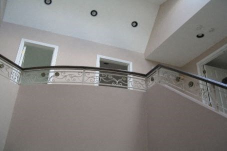 A staircase with a metal railing and a balustrade.