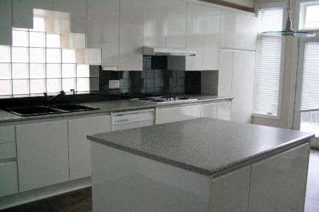 A kitchen with white cabinets and a granite countertop.