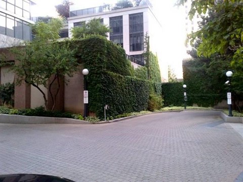 A brick road leads to a building with a white tower.